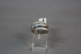 A LATE 20TH CENTURY 18CT WHITE GOLD PAVE DIAMOND SET COILED BAND RING, estimated total diamond