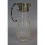 AN EDWARDIAN SILVER MOUNTED CUT AND ETCHED GLASS CLARET JUG, the hinged cover engraved with