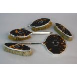 A GEORGE V FIVE PIECE SILVER AND TORTOISESHELL DRESSING TABLE SET, pique work swagged oval design,