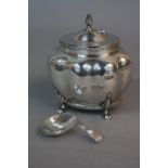 AN EDWARDIAN SILVER TEA CADDY, of lobed oval form, hinged cover, gadrooned rims, on four cabriole