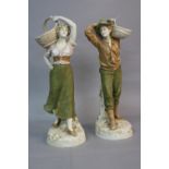 A PAIR OF EARLY 20TH CENTURY ROYAL DUX FIGURES OF A YOUNG MAN AND WOMAN, both with a basket on their