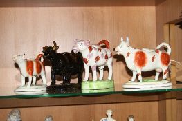 FOUR VARIOUS STAFFORDSHIRE COW CREAMERS (with restorations and chips)