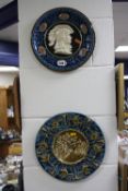 EIGHT RELIEF MOULDED MAJOLICA GLAZED WALL PLATES/CHARGERS, together with a cast iron charger (9)