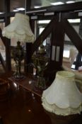 A PAIR OF REGENCY STYLE TABLE LAMPS, a gilt metal and claret glazed ceramic bases, goats head