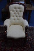 A VICTORIAN BUTTON BACK ARMCHAIR, on brass caps and casters