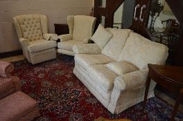 A CREAM FLORALLY UPHOLSTERED THREE PIECE LOUNGE SUITE, comprising of a two seater settee and two