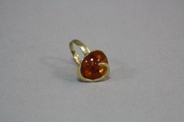 A MODERN 9CT GOLD AMBER SINGLE STONE RING, round cabochon cut stone measuring approximately 15.