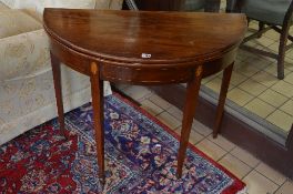 AN EDWARDIAN MAHOGANY AND INLAID DEMI LUNE FOLD OVER CARD TABLE