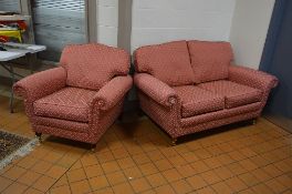 AN UPHOLSTERED TWO PIECE BEIGE SUITE, comprising of a two seater settee and an armchair