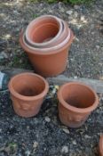 A PAIR OF TERRACOTTA PLANT POTS, and five plastic plant pots (7)