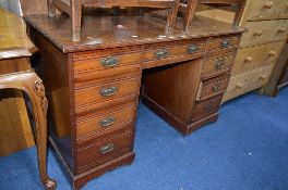 AN EDWARDIAN MAHOGANY KNEE HOLE DESK, with nine various drawers and brass drop down handles