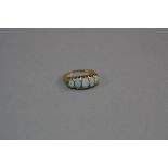 AN EARLY 20TH CENTURY 18CT GOLD FIVE STONE GRADUATED OPAL HALF HOOP RING, white opals with a