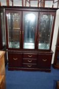 A MODERN MAHOGANY GLAZED THREE DOOR BOOKCASE, above cupboard base with three drawers