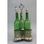 A LATE VICTORIAN THREE BOTTLE DECANTER STAND, foliate pierced design, with three green glass bottles