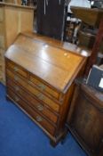 A 19TH CENTURY OAK AND MAHOGANY CROSSBANDED WRITING BUREAU, with fall front and fitted interior,