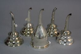 FIVE GEORGE III STYLE EPNS WINE FUNNELS, all fitted with clips and removable sieves (5)