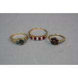 THREE LATE 20TH CENTURY 9CT GOLD DRESS RINGS, to include a green sapphire three stone, a ruby and
