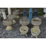 FIVE PRE-CAST GARDEN URNS ON SEPERATE BASES (three urns broken at support) and two other planters (