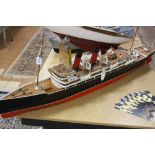 A POWERED MODEL OF A TWO FUNNEL OCEAN LINER, red and black livery similar to Cunard, of wooden and