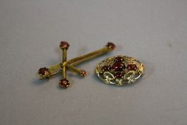 TWO GARNET BROOCHES, one late 20th Century oval openwork scroll design set with cabochon cut
