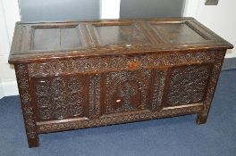 A 17TH CENTURY HEAVILY CARVED OAK TRIPLE PANEL BLANKET CHEST