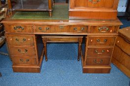 A YEW WOOD PEDESTAL DESK, with green tooled leather inlay top and nine various drawers,