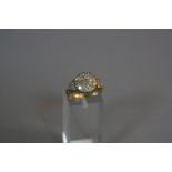 AN EDWARDIAN DIAMOND CLUSTER RING, set with sixteen round and cut diamonds in a circular cluster, to