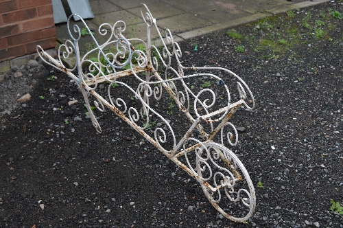 A PAINTED IRON GARDEN FEATURE, shaped as a wheelbarrow in foliate design