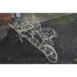 A PAINTED IRON GARDEN FEATURE, shaped as a wheelbarrow in foliate design