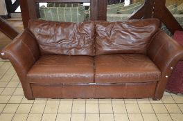 A BROWN LEATHER TWO SEATER SETTEE