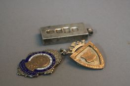 TWO SILVER FOBS, and a silver ignot, approximate weight 64.4 grams