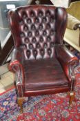 AN OX BLOOD BUTTONED WING BACK ARMCHAIR, approximate size height 97cm and inner arm width 43cm (sd)