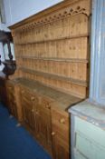 A LARGE 20TH CENTURY PINE KITCHEN DRESSER, with three tier plate rack above five various drawers and