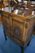 A CARVED OAK TWO DOOR DRINKS CABINET, approximate size 92cm x height 122cm x depth 45cm