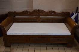 A LARGE CARVED HARDWOOD THREE SEATER BENCH, with scroll ended arms, three drawers and removable