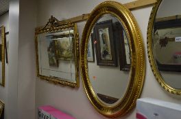 A RECTANGULAR GILT WALL MIRROR, with carved surmount and an oval bevelled edge wall mirror (2)