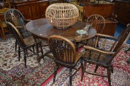 AN OAK BARLEY TWIST OVAL GATE LEG TABLE, and six wheel back chairs including two carvers