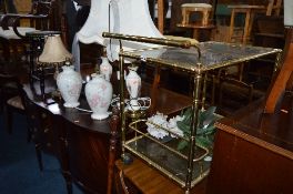 A BRASS FRAMED TEA TROLLEY, with glass inserts, five various table lamps, painted stool,