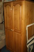 A PINE TWO DOOR WARDROBE, three wicker chairs and a similar occasional table (5)