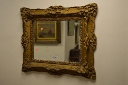 A VICTORIAN GILT BEVELLED EDGE WALL MIRROR, with moulded foliate detail, approximate size width 78cm