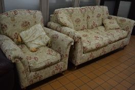 A FLORAL UPHOLSTERED TWO PIECE SUITE, comprising of a two seater settee and an armchair