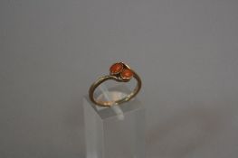 A 9CT GOLD AND CORAL TWO STONE TWIST RING, ring size N, approximate weight 2.0 grams