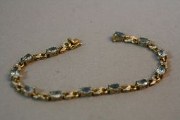 A MODERN 9CT GOLD BLUE TOPAZ AND DIAMOND BRACELET, measuring approximately 180mm in length,