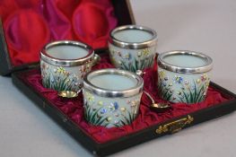 A LATE 19TH CENTURY CASED SET OF FOUR FRENCH OPAQUE GLASS CIRCULAR SALTS, enamelled with flowers and