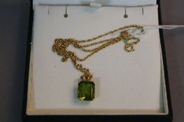 A YELLOW METAL PENDANT SET, with a green stone on a 14k chain