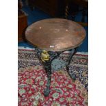 A CAST IRON CIRCULAR PUB TABLE, with copper top and foliate detail to the base, approximate size