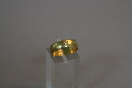AN 18CT GOLD BAND SET WITH A DIAMOND, ring size L, approximate weight 4.8 grams