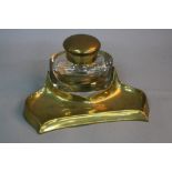 A VICTORIAN BRASS DESKSTAND, fitted with an oval glass inkwell of large proportions, circular