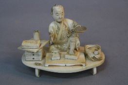 A LATE 19TH CENTURY CARVED IVORY FIGURE OF AN ARTIST, seated cross legged with brush and palette