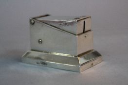 AN EDWARDIAN SILVER TABLE TOP CIGAR AND CIGARETTE CUTTER, cutting action opens drawer to the base,